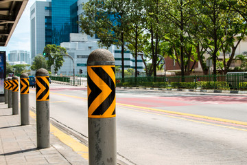 A row of black and yellow metal barrier on the road