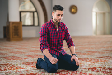 Fototapeta premium Humble Muslim praying while kneeling
