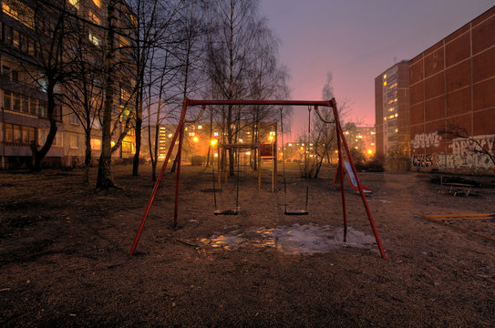 Empty swings on playground in poor city