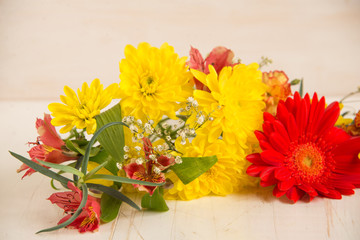 Composition of  bright flowers on a wooden table