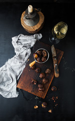Grilled chestnuts on a wooden board and a glass of wine
