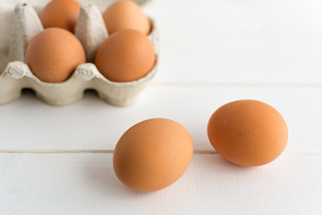 Open eggbox on wooden white background.