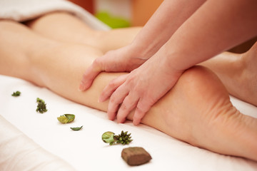 Obraz na płótnie Canvas Detail of hands massaging human calf muscle.Therapist applying pressure on female leg