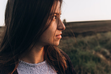 stylish hipster woman looking at sunlight in summer evening field. atmospheric moment. summer...