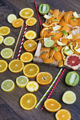Assorted cut citrus fruits on wooden background