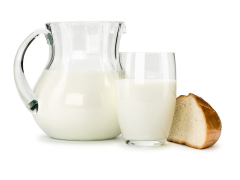 Piece of a white loaf and glassware filled with milk
