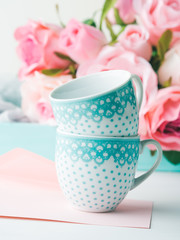 Blank pink paper card for Valentine's or mother woman day. Wedding baby birthday romantic date invitation. Background with roses tray romantic textile and two coffee cups