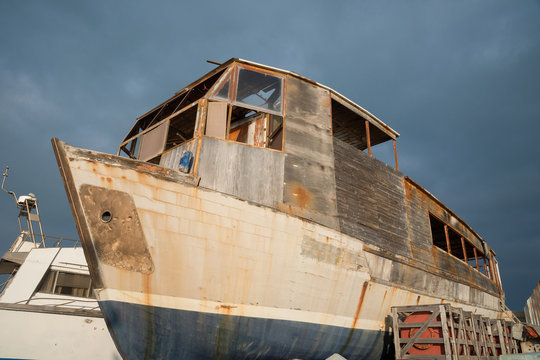 Old fishing boat parked on land for restoration
