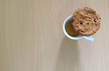 Top View of Oatmeal Raisin Cookie with a Cup of Coffee on the Wooden Table 