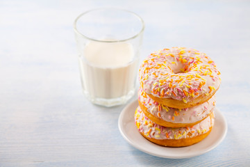 vanilla donuts with milk on a blue wooden background