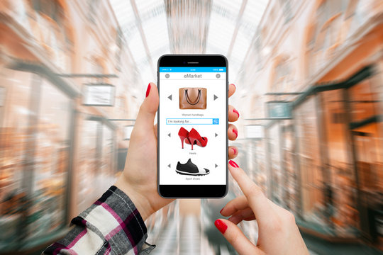 Women in mall shopping online on modern phone