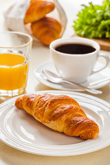 croissant with coffee and orange juice on a white background