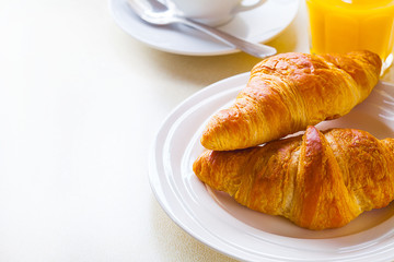 croissant with coffee and orange juice on a white background