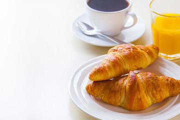 croissant with coffee and orange juice on a white background