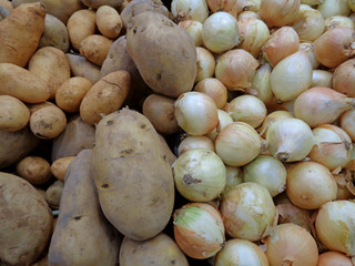 Heap of uncooked potatoes and onions