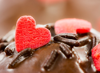 Detail of a chocolate muffin with red sugar hearts