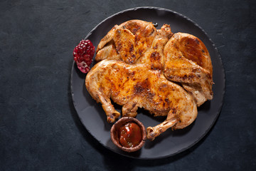 Grilled Roasted сhicken tabaka on a black stone plate