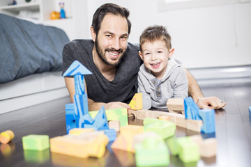 cute child playing with color toy indoor with is dad