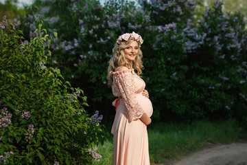 Portrait of beautiful pregnant woman in spring or summer park