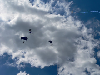 Two parachutist in clouds on sunny day