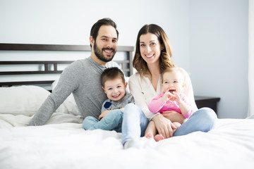 Fototapeta premium four peoples family on a white bed.