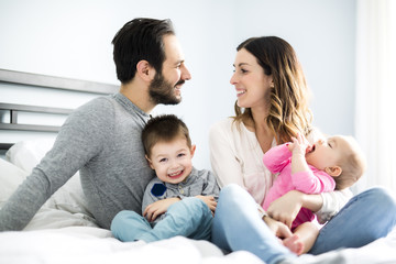Fototapeta premium four peoples family on a white bed.