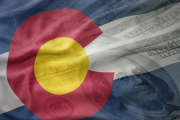 colorful waving flag of colorado state on a american dollar money background. finance concept
