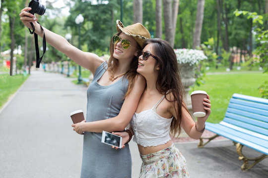 Happy tourists girl friends taking selfie photos