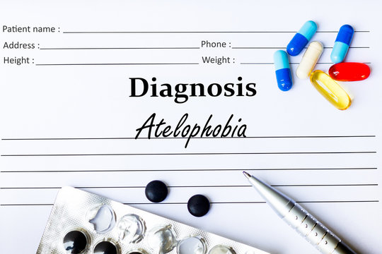 Atelophobia - Diagnosis written on a piece of white paper with medication and Pills
