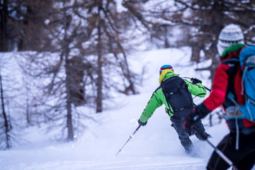Couple skiing down a piste