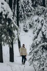 Ancient viking hunter walking in snow winter forest with steel axe and sword, viking warrior hunting in scandinavian woods before battle, thor cosplay outdoors, northern knight concept