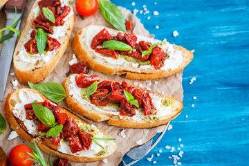 Bruschetta with cream cheese, pesto, fresh basil and sun dried tomatoes