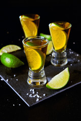 Strong alcohol drinks. Tequila shots with salt and lime slices.