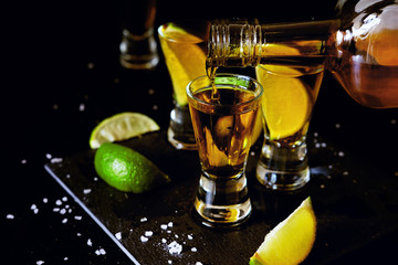 Strong alcohol drinks. Tequila shots with salt and lime slices.