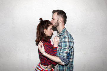 beautiful couple standing by the wall