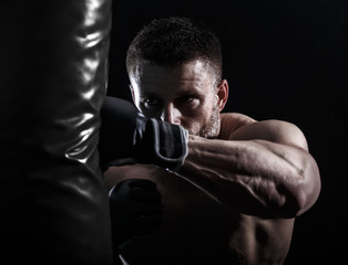 Fototapeta na wymiar Studio shot of male boxer punching a boxing bag.