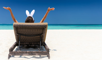 Frau mit Hasenohren relaxt am tropischen Strand
