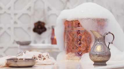 Water jar, towel and copper bowl with soap foam in turkish hamam. Traditional interior details - obrazy, fototapety, plakaty