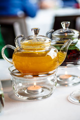 Tea from sea buckthorn in a glass teapot with a candle.