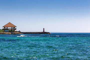 wooden house Bungalow and a lighthouse on the seashore