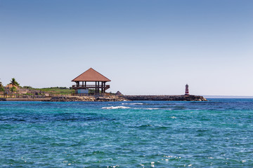 wooden house Bungalow and a lighthouse on the seashore
