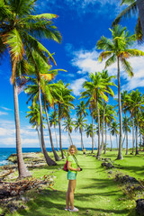 Young girl traveller on the green road with palm trees. Caribbean vacation. Samana, Dominican Republic