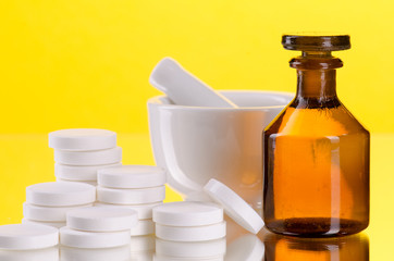 Tabletten mit Mörser und kleiner brauner medizinischer Flasche