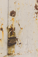Old rusty lock on the vintage rural metal door