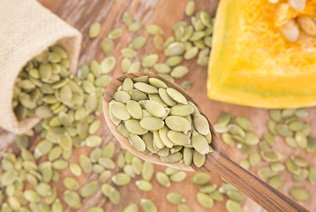 Pumpkin seeds on the wooden background