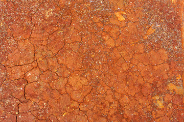 textured background of cracked red soil