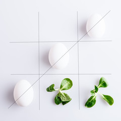 Tick-tack-toe from white eggs and corn leaves