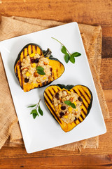 Pumpkin Acorn Stuffed with Quinoa, Nuts and Dried Fruit. Selective focus.
