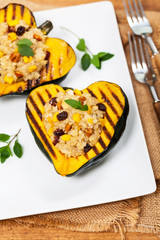 Pumpkin Acorn Stuffed with Quinoa, Nuts and Dried Fruit. Selective focus.
