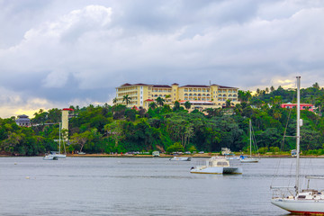 luxury vacation on catamaran near green shore with beautiful architecture